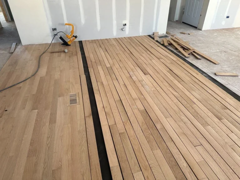Continuing laying rows of hardwood on the floor