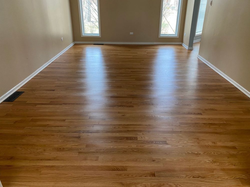 Living room with medium-tone oak hardwood floor, semi-gloss polyurethane finish.