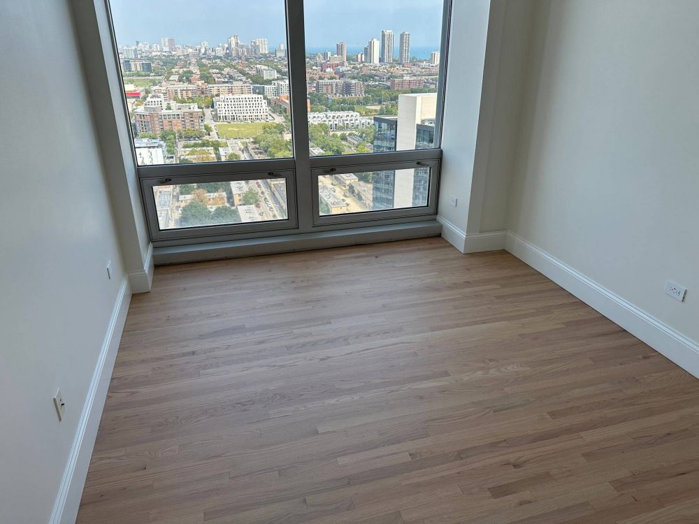 Red oak hardwood floors refinished near windows in a downtown condo