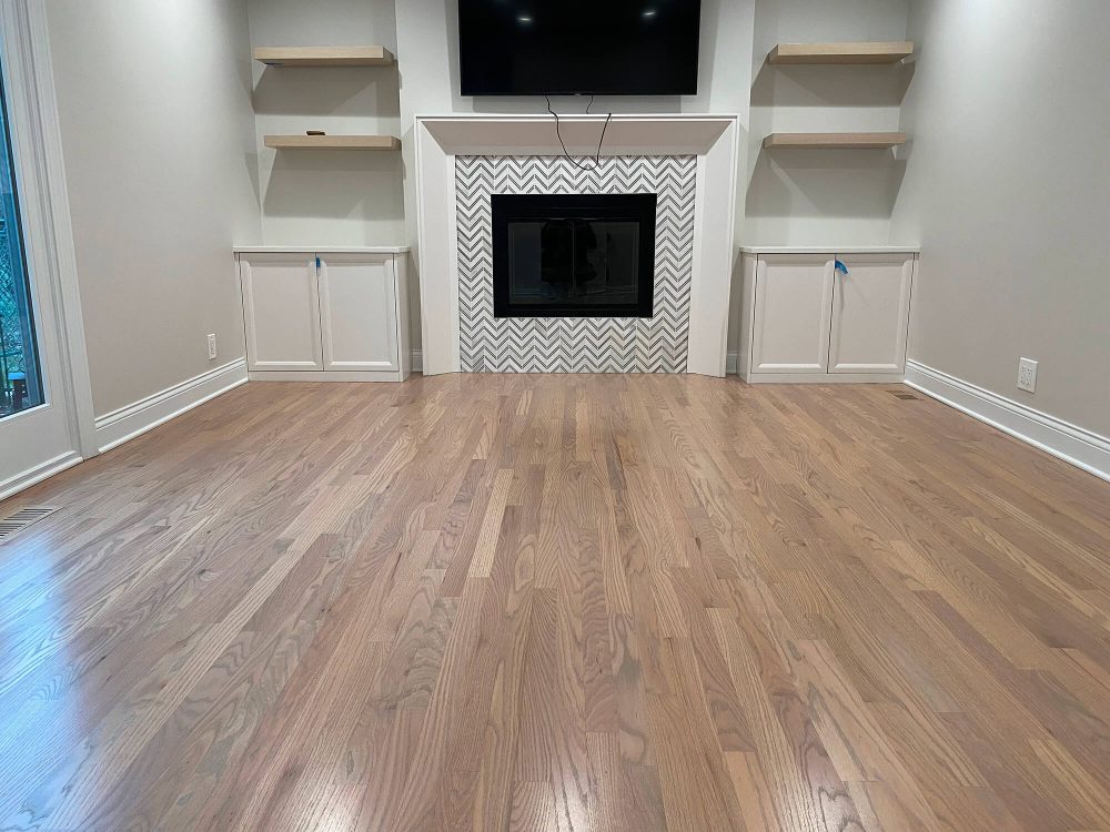 Finished hardwood floor with silvered stain in a living room, showing the visual payoff that drives many carpet-to-hardwood upgrades
