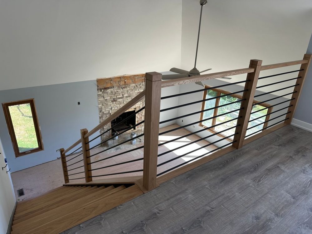 Stair installer fitting a white oak handrail during staircase remodel in West Chicago