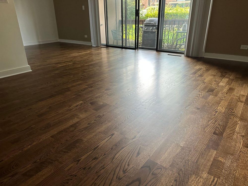 A wide after view of the living room shows how our refinishing work gave the engineered white oak floor a deeper, more polished appearance.