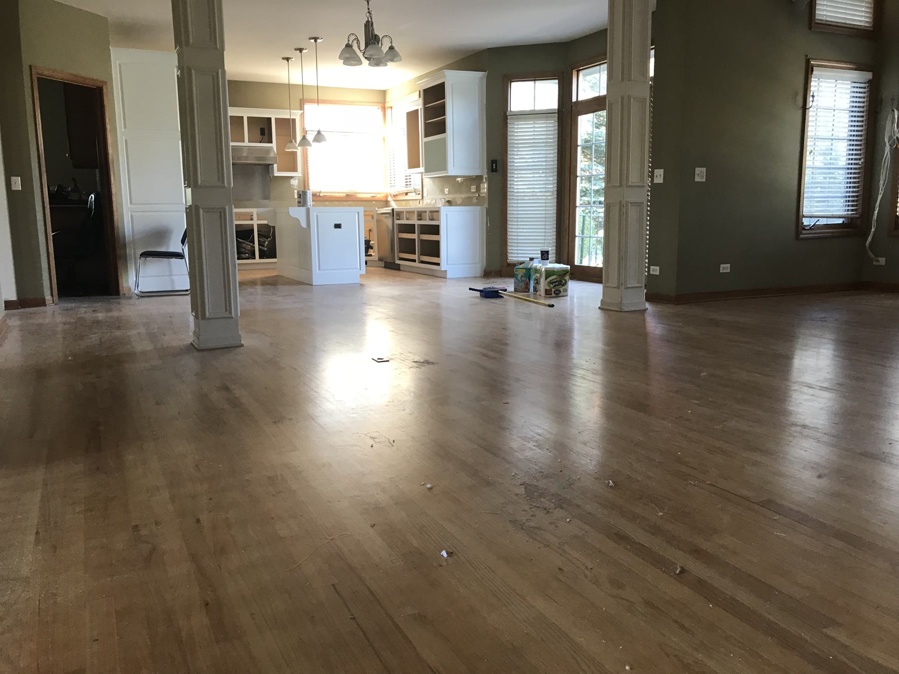Open kitchen and great room with the original light hardwood floor before staining, Batavia, IL