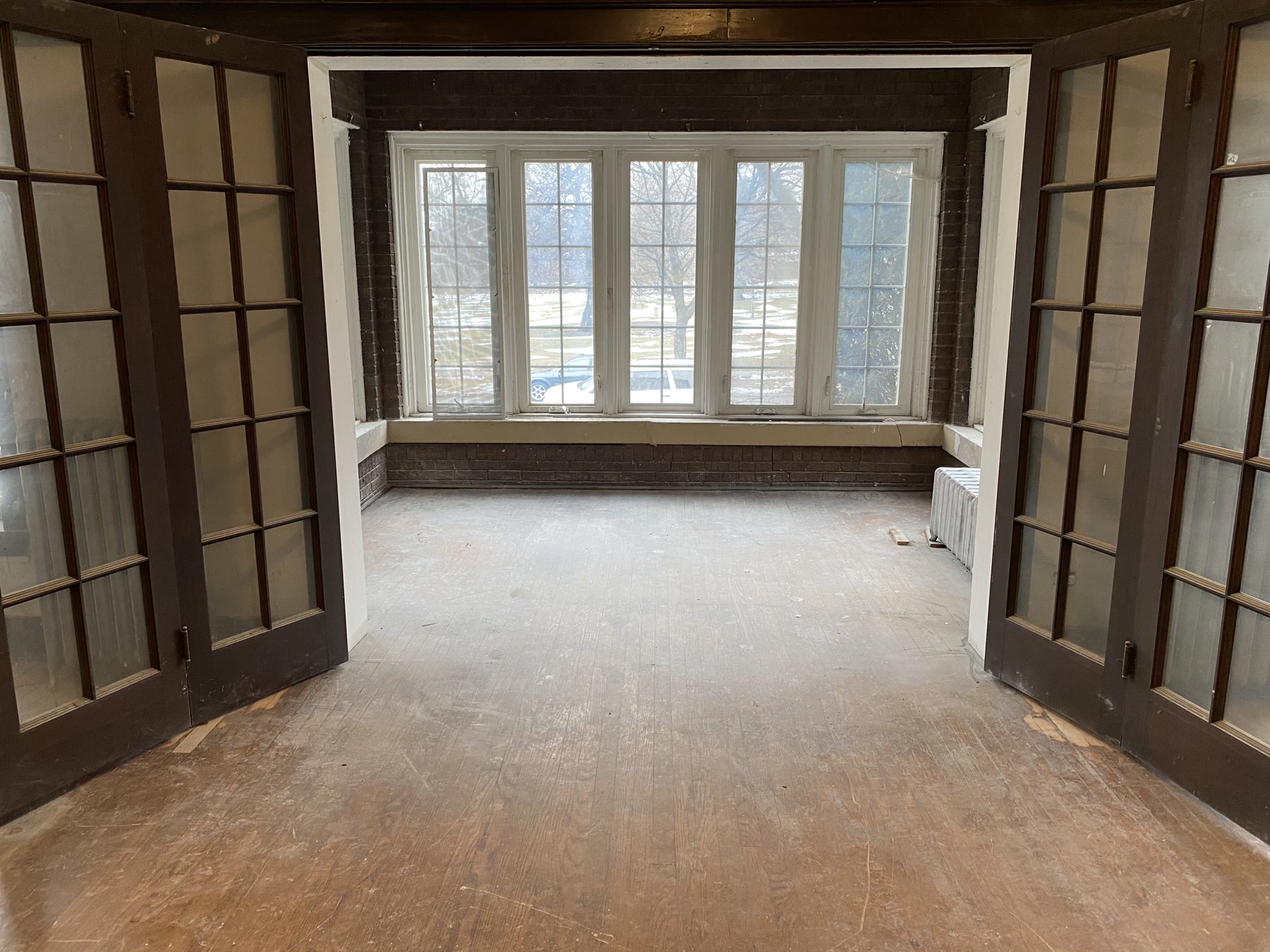 Worn, bare vintage floor with French doors before refinishing, Bolingbrook, IL