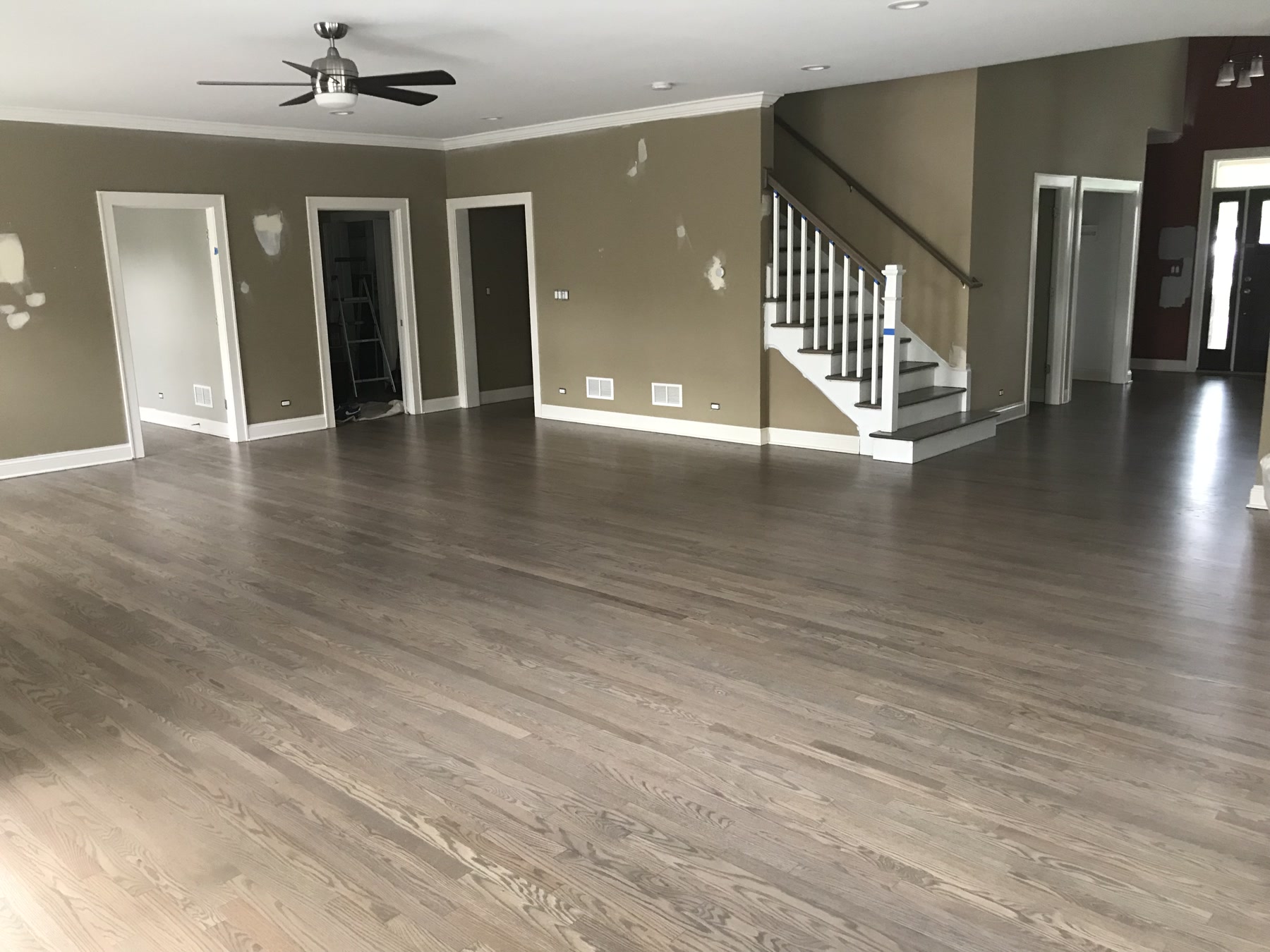 Hardwood floor stained a custom silvered grey in the great room with staircase, Downers Grove, IL