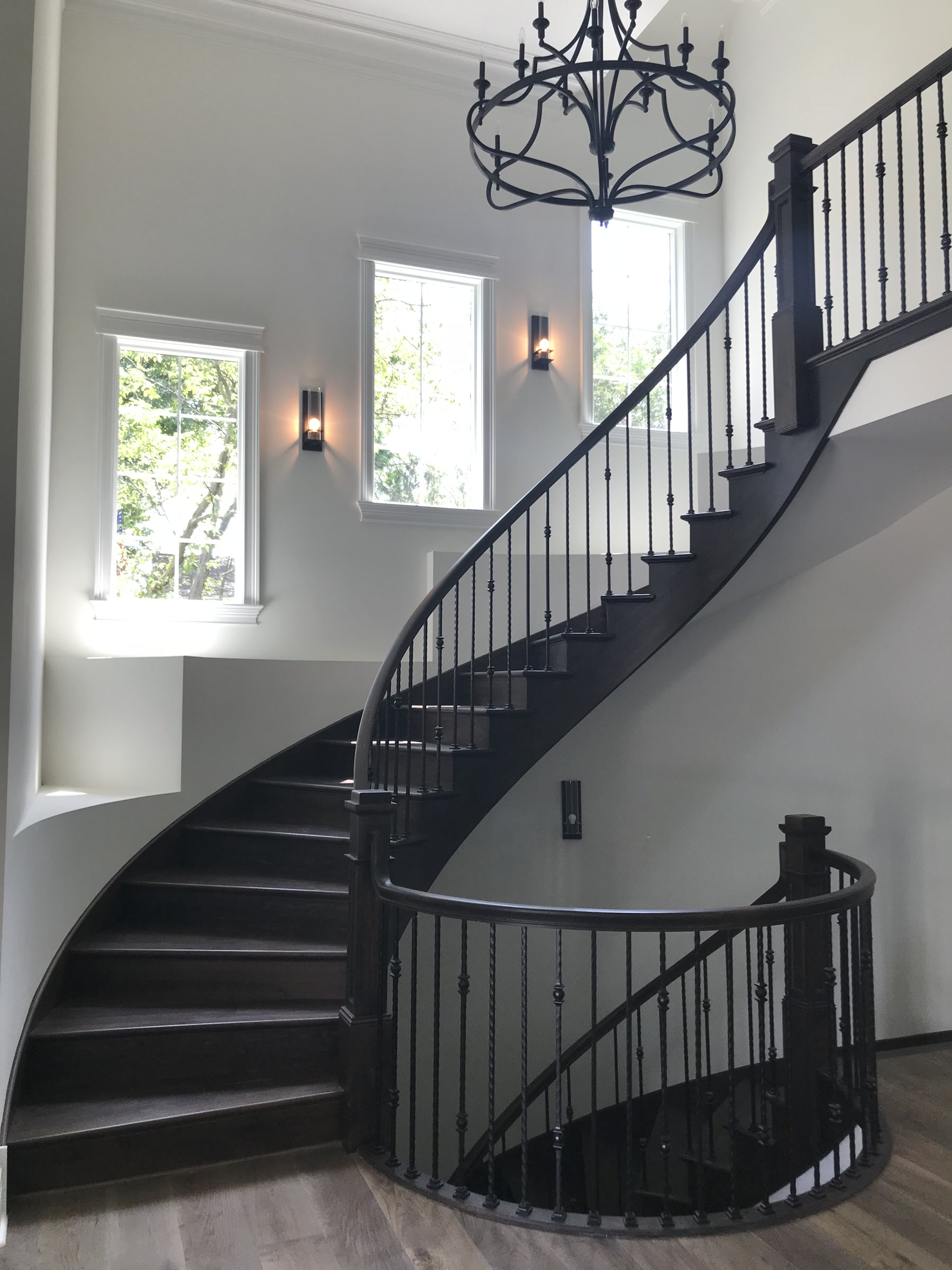 The same staircase finished with dark treads and iron balusters, Downers Grove, IL