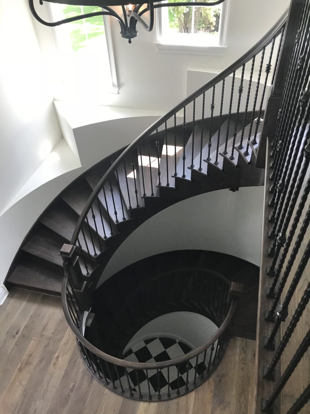 Curved staircase with dark treads and black iron balusters, Downers Grove, IL
