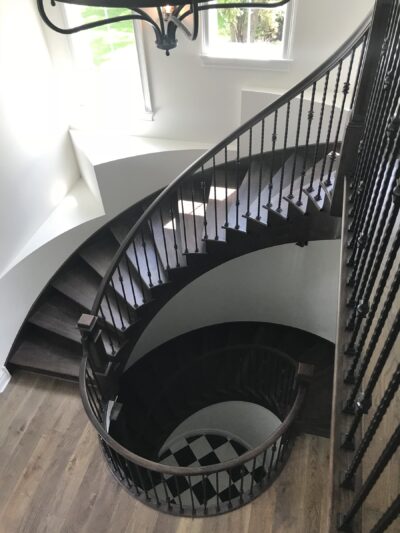 Curved staircase with dark treads and black iron balusters, Downers Grove, IL