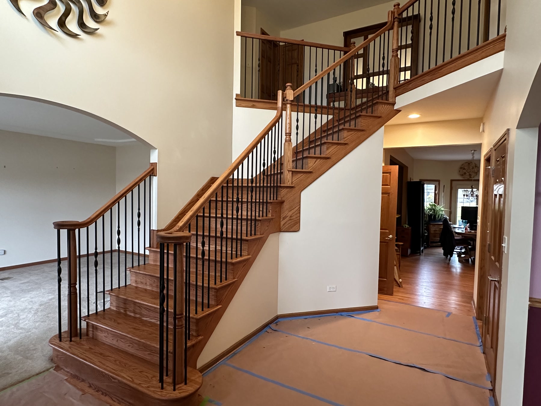 The restored curved staircase with refinished treads and black metal balusters, Elmhurst, IL