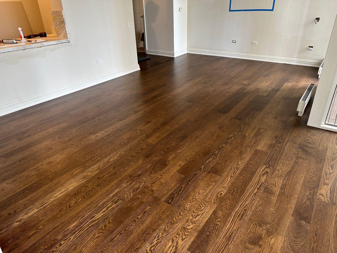 Completed engineered white oak flooring across the main living area after staining and refinishing.