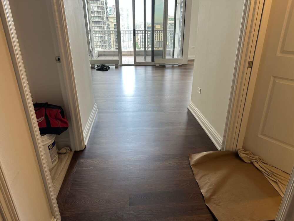 Finished engineered white oak flooring through the condo entry hall leading into the main living area.
