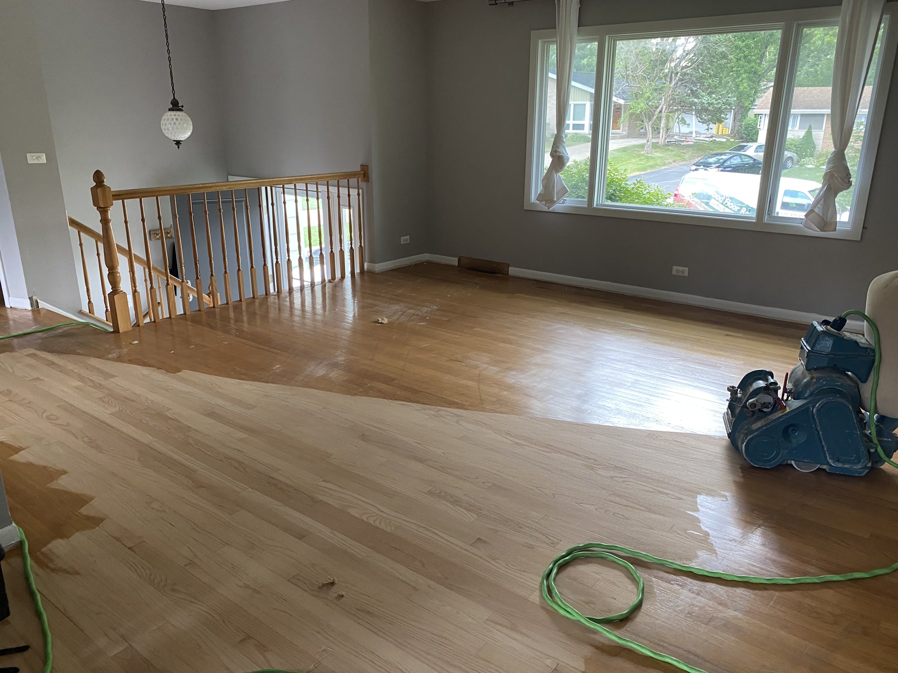 Hardwood floor being sanded with the machine in the open living space, Lake Forest, IL (in-process)