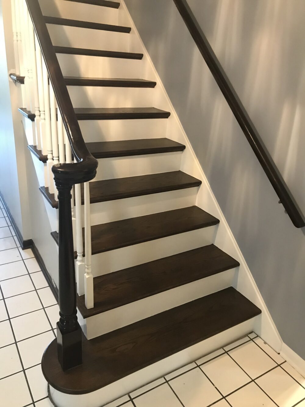 Finished staircase with espresso treads and carved newel posts, Lemont, IL