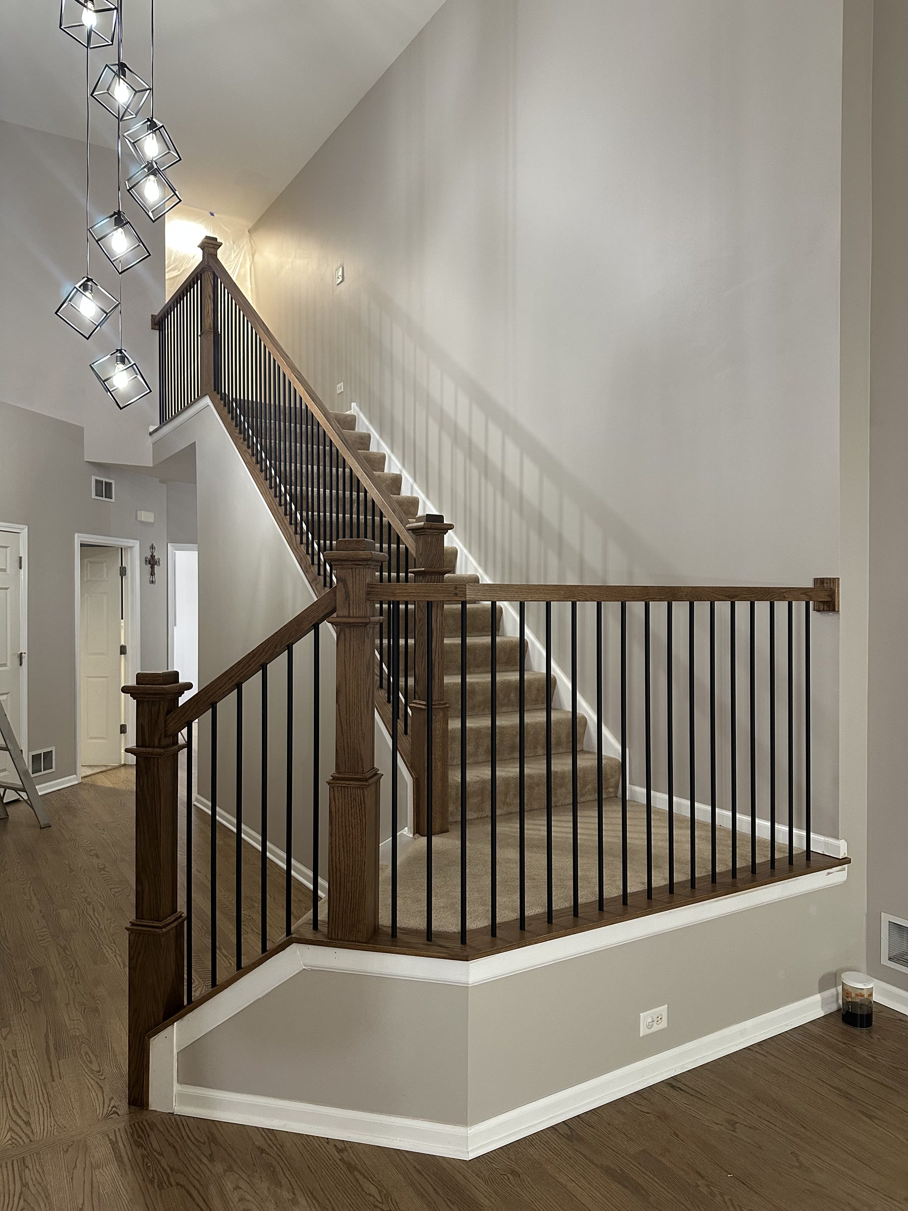 Staircase with new dark newels and black metal balusters, Oswego, IL