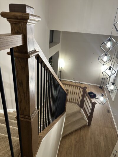 Finished staircase and landing with the dark handrail and black metal balusters, Oswego, IL