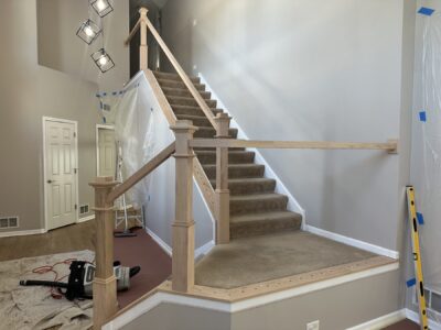 New wood newel posts and handrail being installed with the carpet still on the stairs, Oswego, IL (in-process)