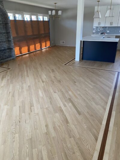 Natural hardwood floor with a dark border inlay by the kitchen, West Chicago, IL