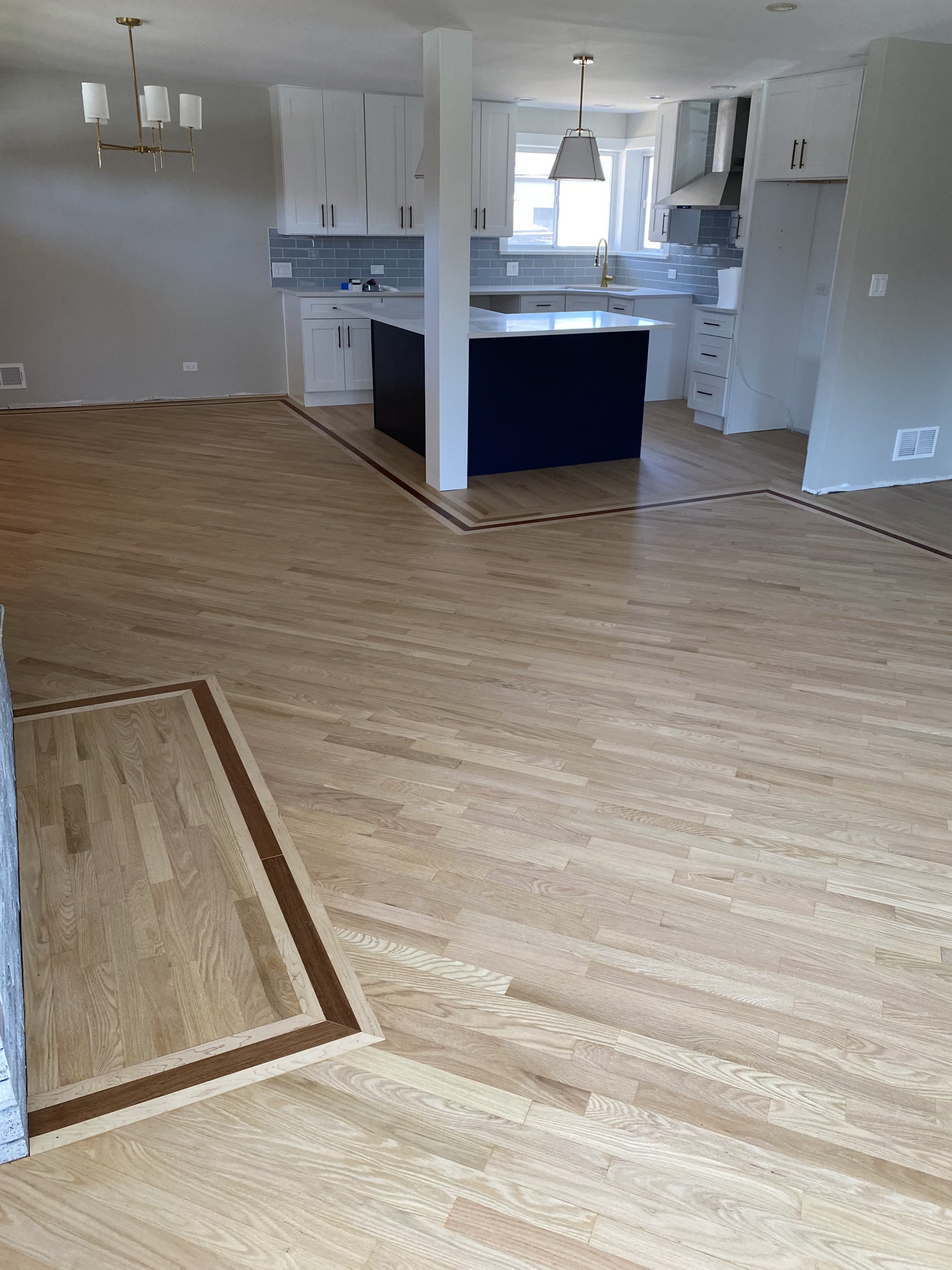 Natural hardwood floor by the kitchen island with a border inlay, West Chicago, IL