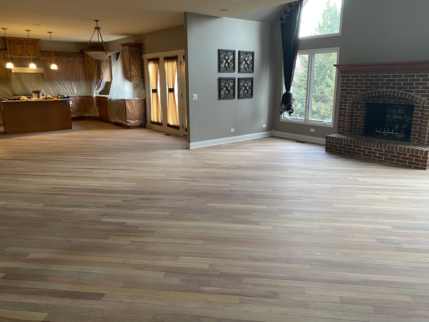 Great room with brick fireplace and open kitchen, dull Brazilian cherry floor before finishing, Wilmette, IL