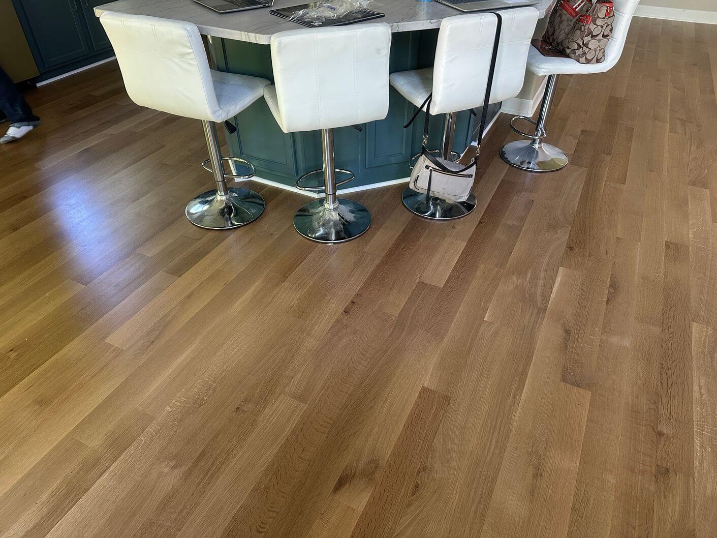Finished rift and quartered white oak flooring installed around the kitchen island in the Aurora home.