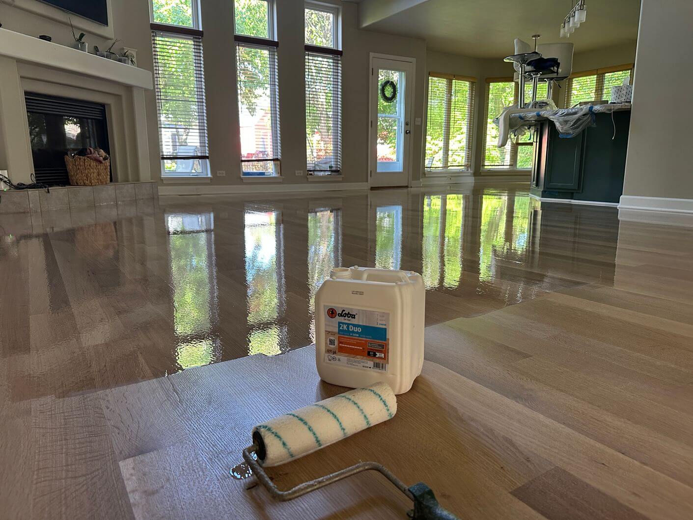 Loba 2K Duo being rolled onto the newly sanded white oak floor during finishing.