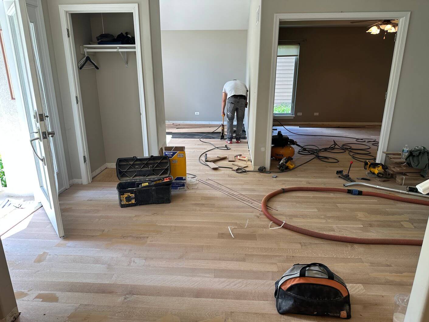 White oak installation progressing through connected rooms to create one continuous hardwood floor.