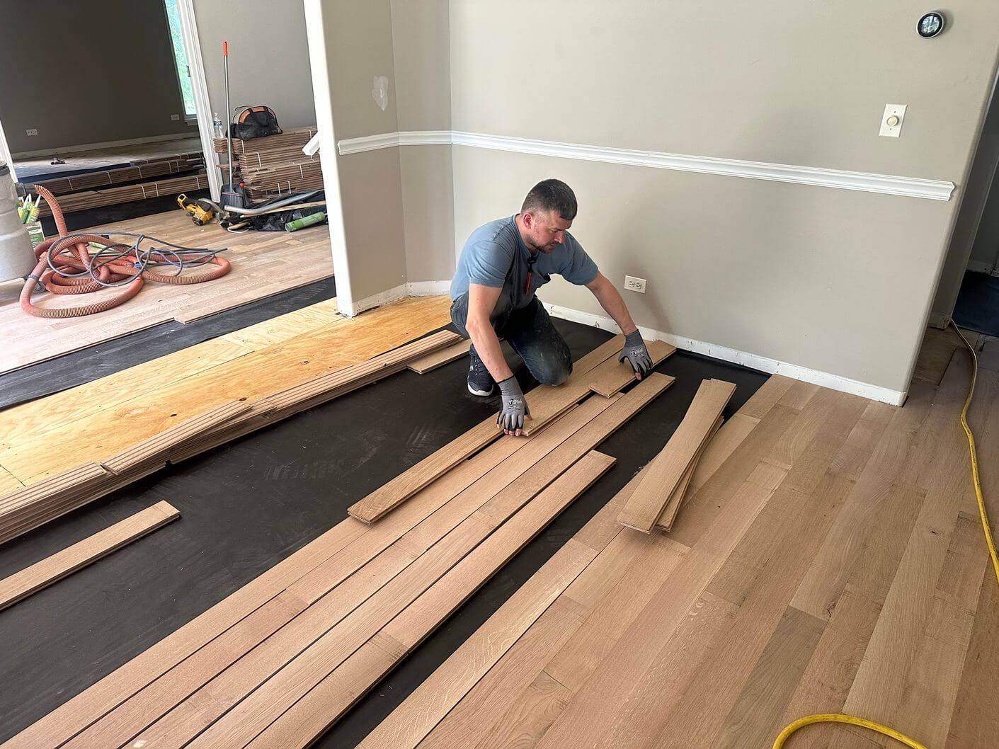 Rift and quartered white oak flooring being installed over moisture-control underlayment.