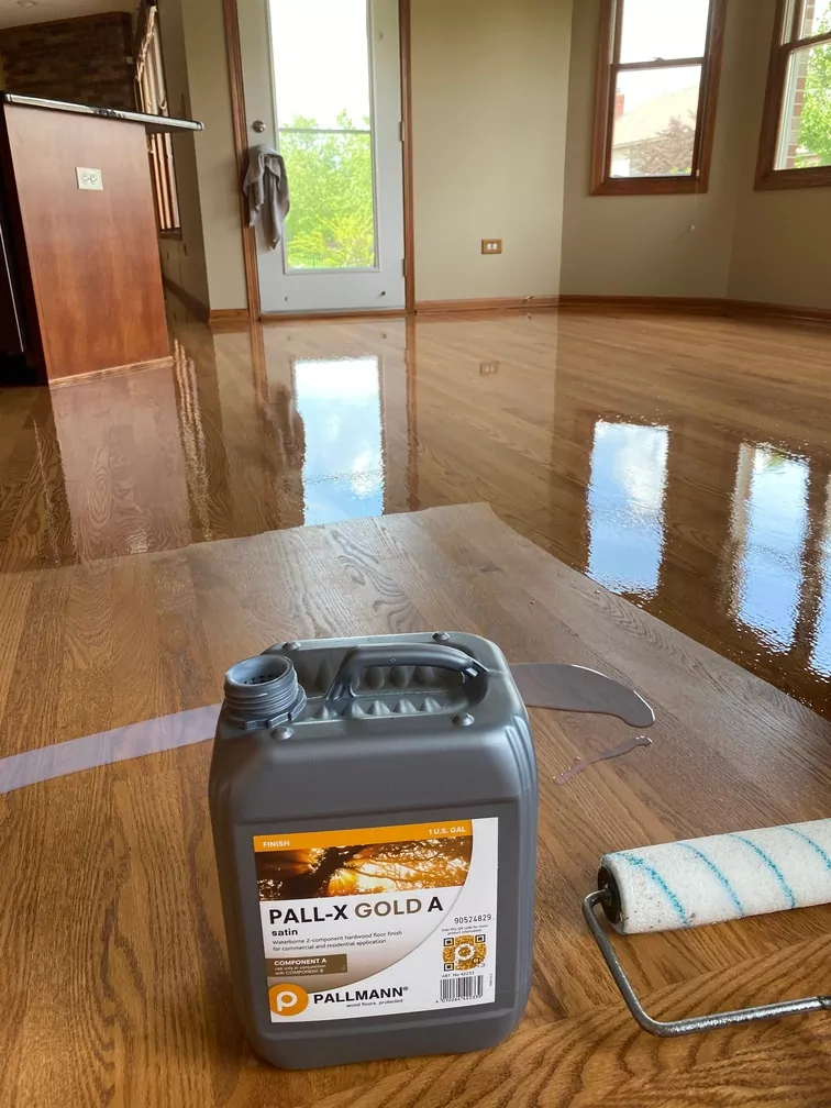 Hardwood floor refinishing using Pall-X Gold satin finish with a roller applicator.