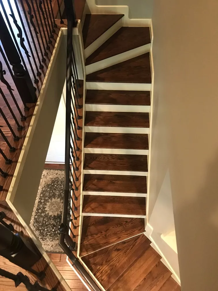 Refinished hardwood stairs with a rich dark stain and white accents.
