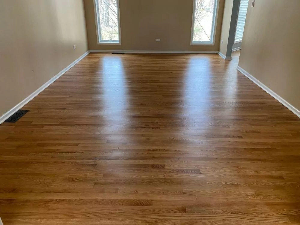 Living room with medium-tone oak hardwood floor, semi-gloss polyurethane finish.
