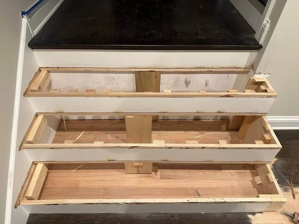 Staircase tread and riser framing being rebuilt for hardwood installation.