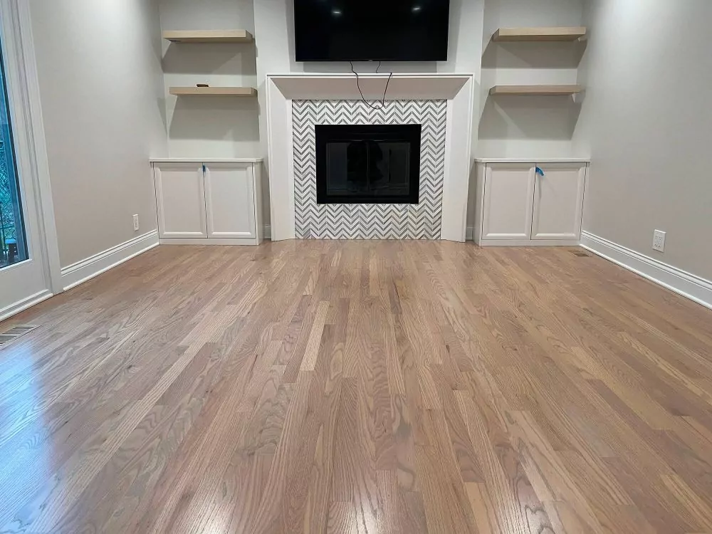 Finished hardwood floor with silvered stain in a living room, showing the visual payoff that drives many carpet-to-hardwood upgrades