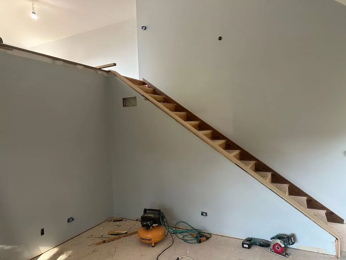 Staircase railing installation on loft: white oak posts with horizontal iron spindles