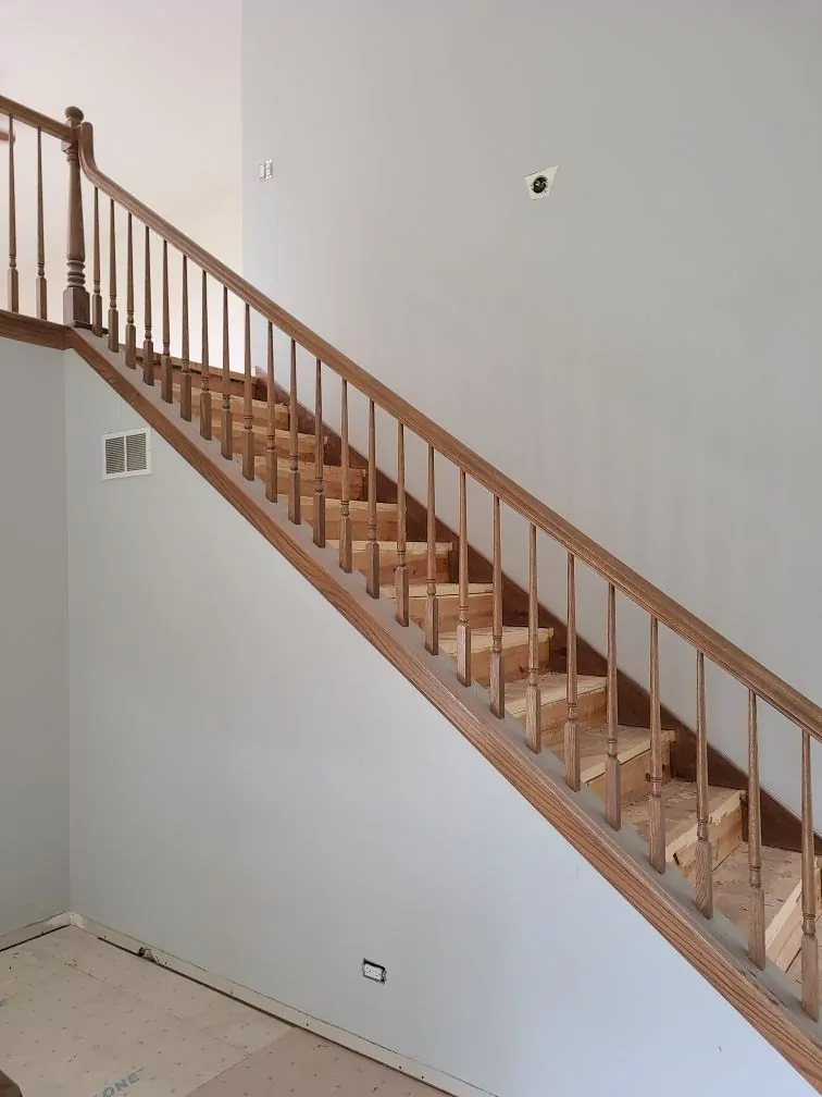 Before staircase railing replacement: old wood spindles and handrail in West Chicago, IL