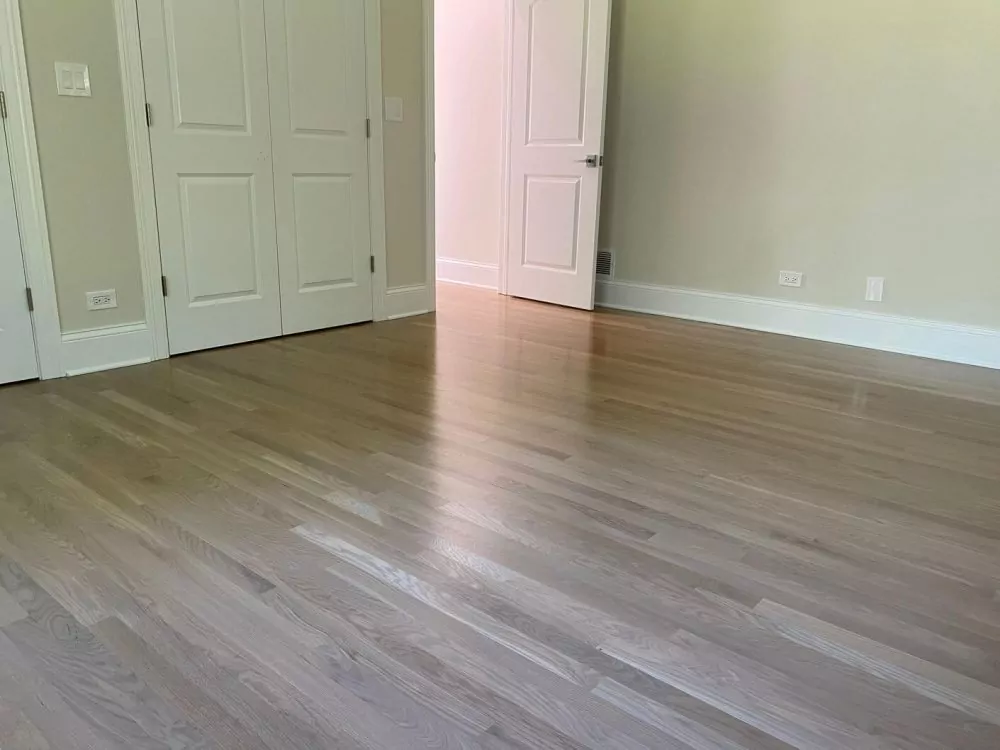 Light white oak hardwood floor in a bedroom, with pale color, gentle grain movement, and the balanced look that makes white oak a common choice for modern interiors